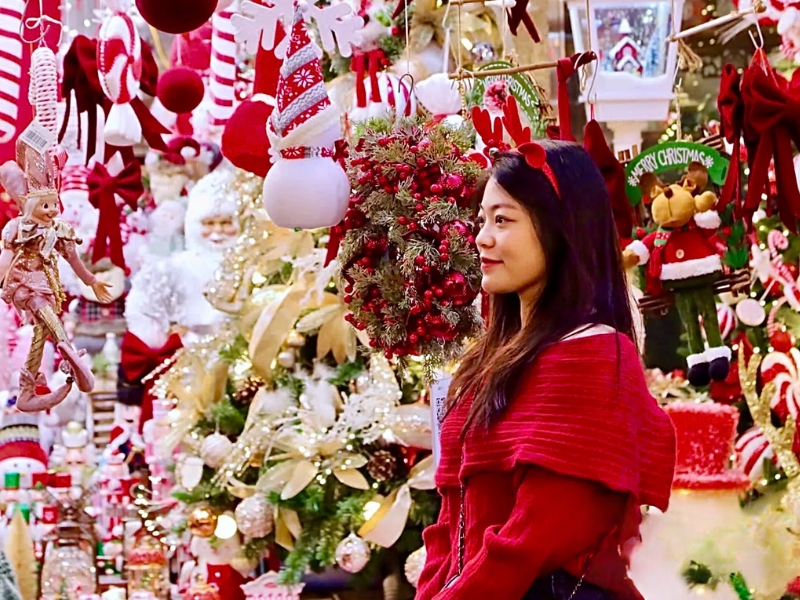 tạo dáng đứng trước cửa hàng trang trí noel